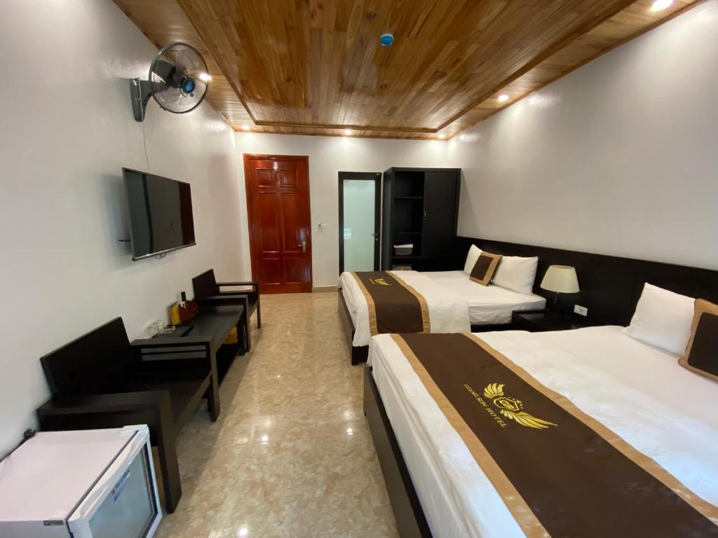 um quarto de hotel com duas camas e uma televisão de ecrã plano em Nhà nghỉ Giang Sơn em Bắc Hà