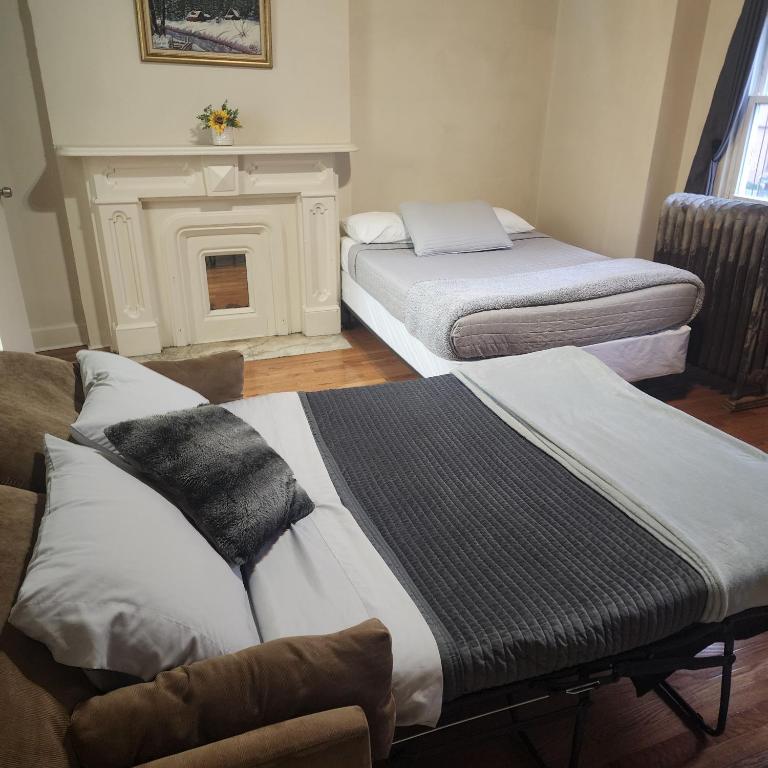 two beds in a room with a fireplace at New York City GuestHouse in New York