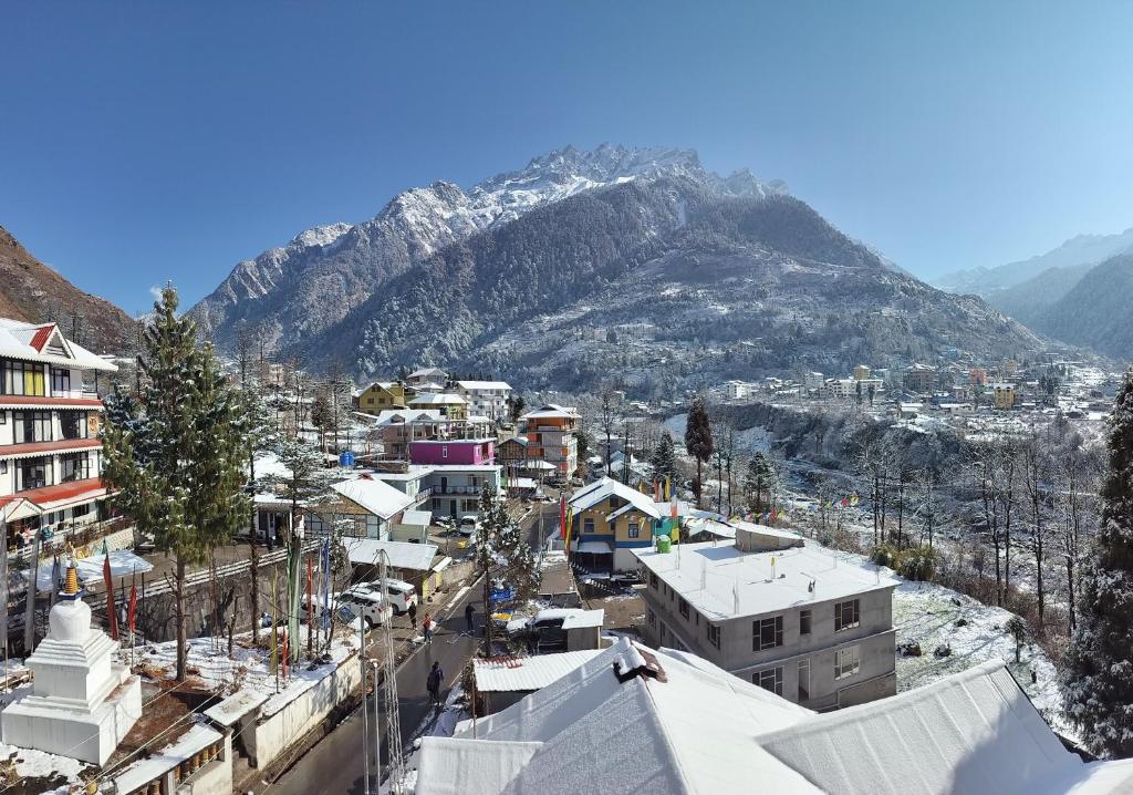 uma cidade com uma montanha de neve no fundo em Montanamar Lachung em Lachung