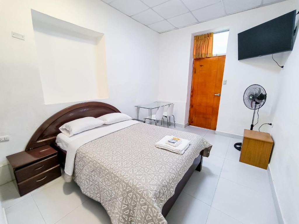 um quarto com uma cama grande e uma ventoinha em SANTA VICTORIA HOUSE em Chiclayo