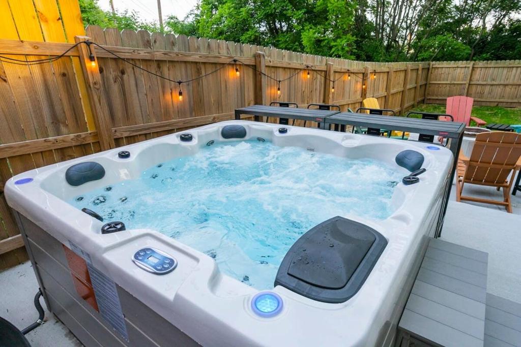 a hot tub in a backyard with a fence at Vacation Haven HOT TUB FIRE PIT GRILL & ARCADE in Nashville
