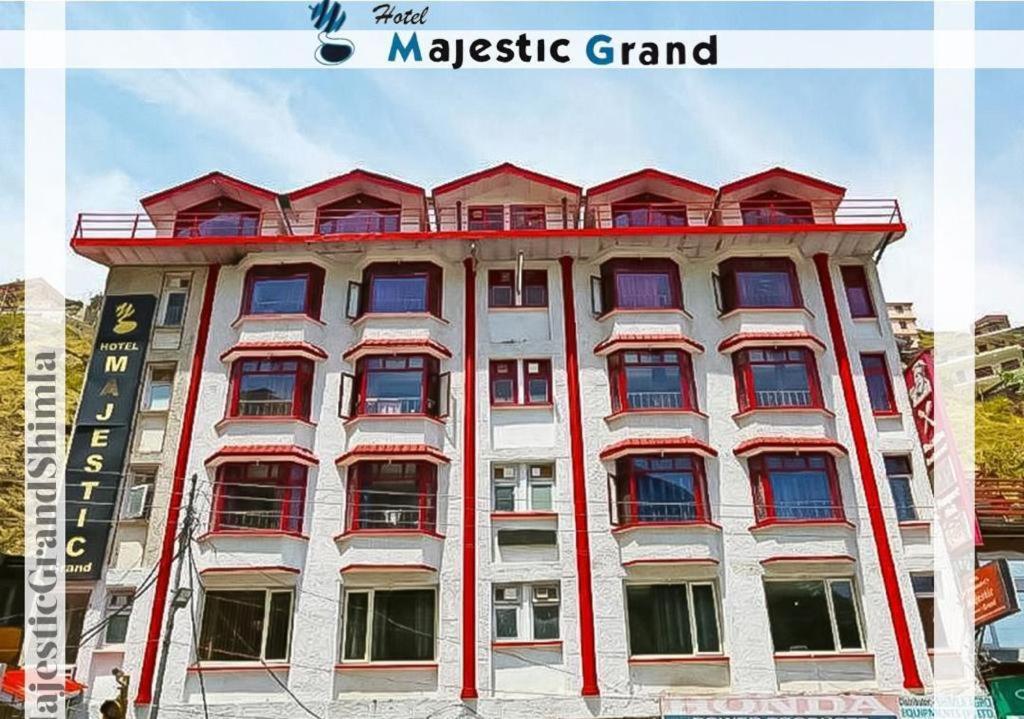 ein großes weißes Gebäude mit roten Fenstern in der Unterkunft Hotel Majestic Grand in Shimla
