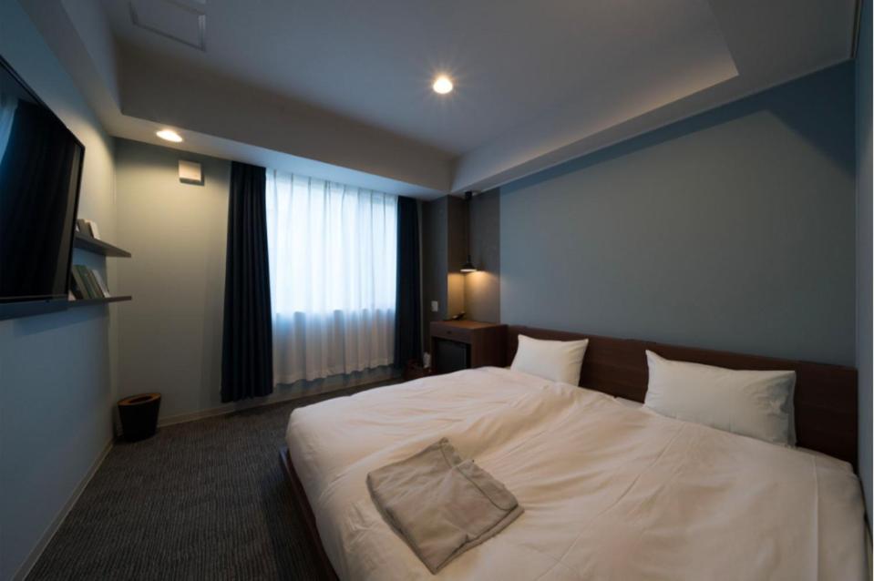 Postel nebo postele na pokoji v ubytování BOOK HOTEL 京都九条
