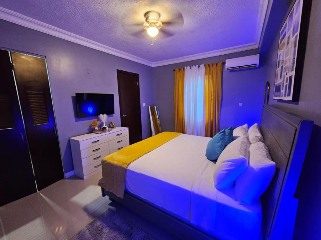 a bedroom with a bed with blue lights on it at Paradise Haven at Hamptons - -across from Ac Marriot Hotel in Kingston