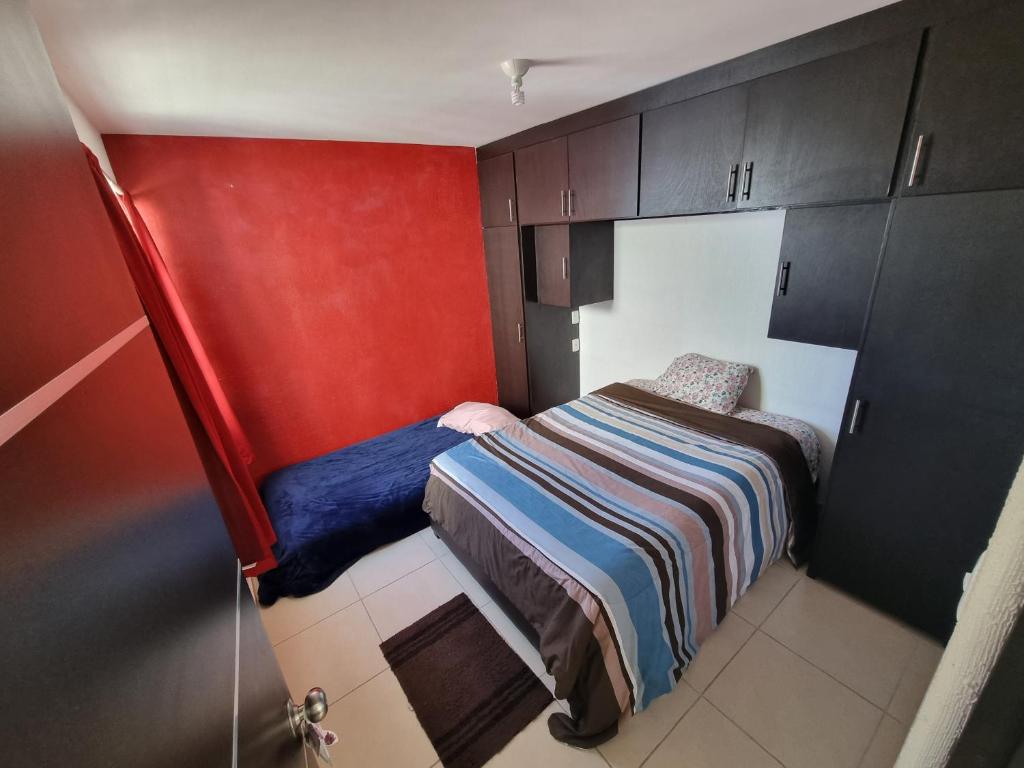 Dormitorio pequeño con cama y armarios en Habitacion Lomas de San Pedro, en Carrillo