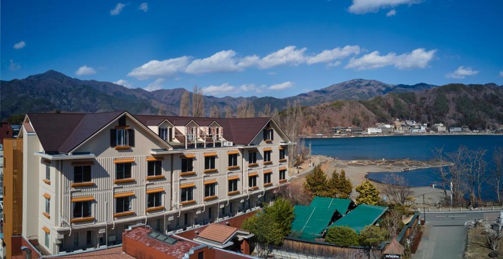 富士河口湖町にあるロイヤルホテル河口湖の湖と山の景色を望む建物