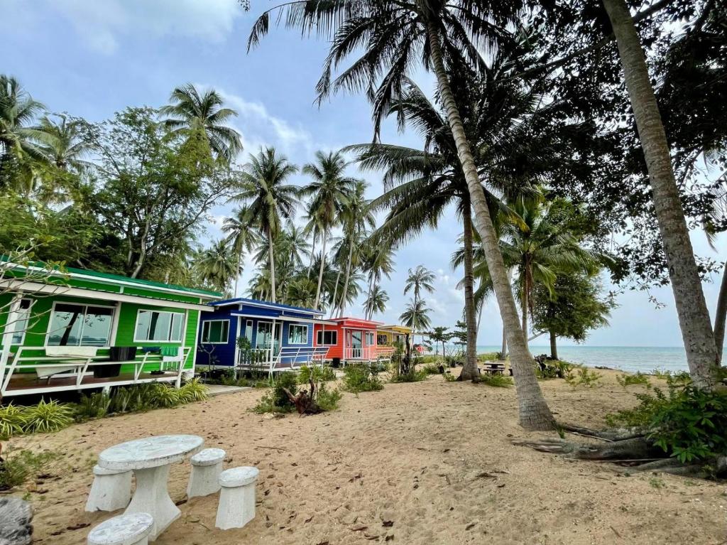 una fila de casas coloridas en una playa en HomeState Bang Maprao en Ban Hin Sam Kon