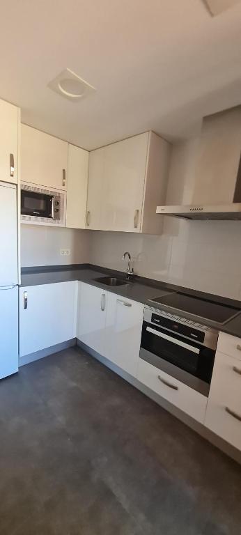 una cocina vacía con armarios blancos y fregadero en Apartamento Bulevar, en Burgos