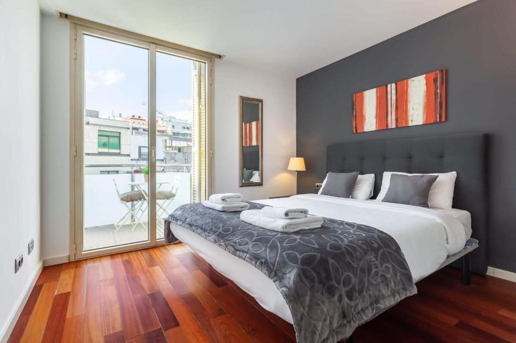 1 dormitorio con cama grande y ventana grande en 3bedroom Duplex with balcony in plaza Cataluña, en Barcelona