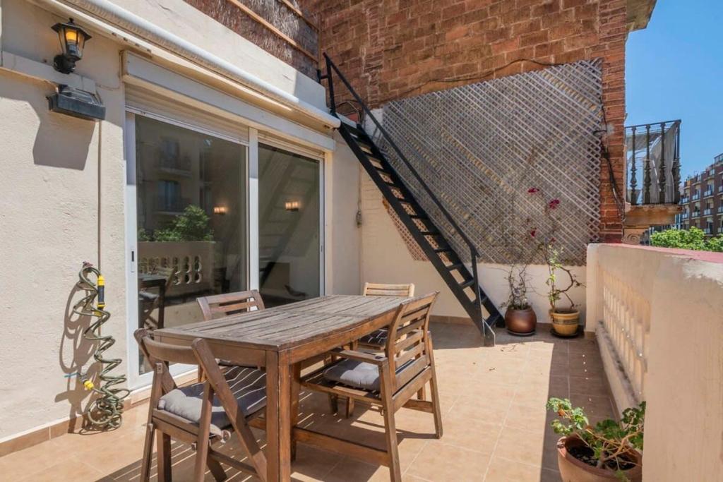 a wooden table and chairs on a patio at 3BD with private terrace right by Sagrada Familia in Barcelona