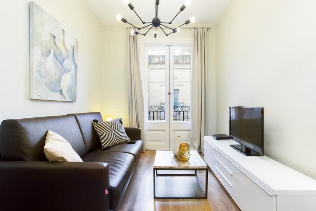 a living room with a couch and a flat screen tv at Centric 2bedroom in Las Ramblas 3 1A in Barcelona