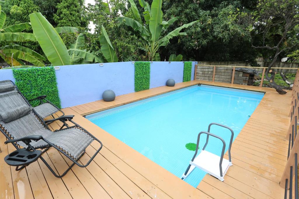 a swimming pool with two chairs and a table at Hidden gem in Kingston