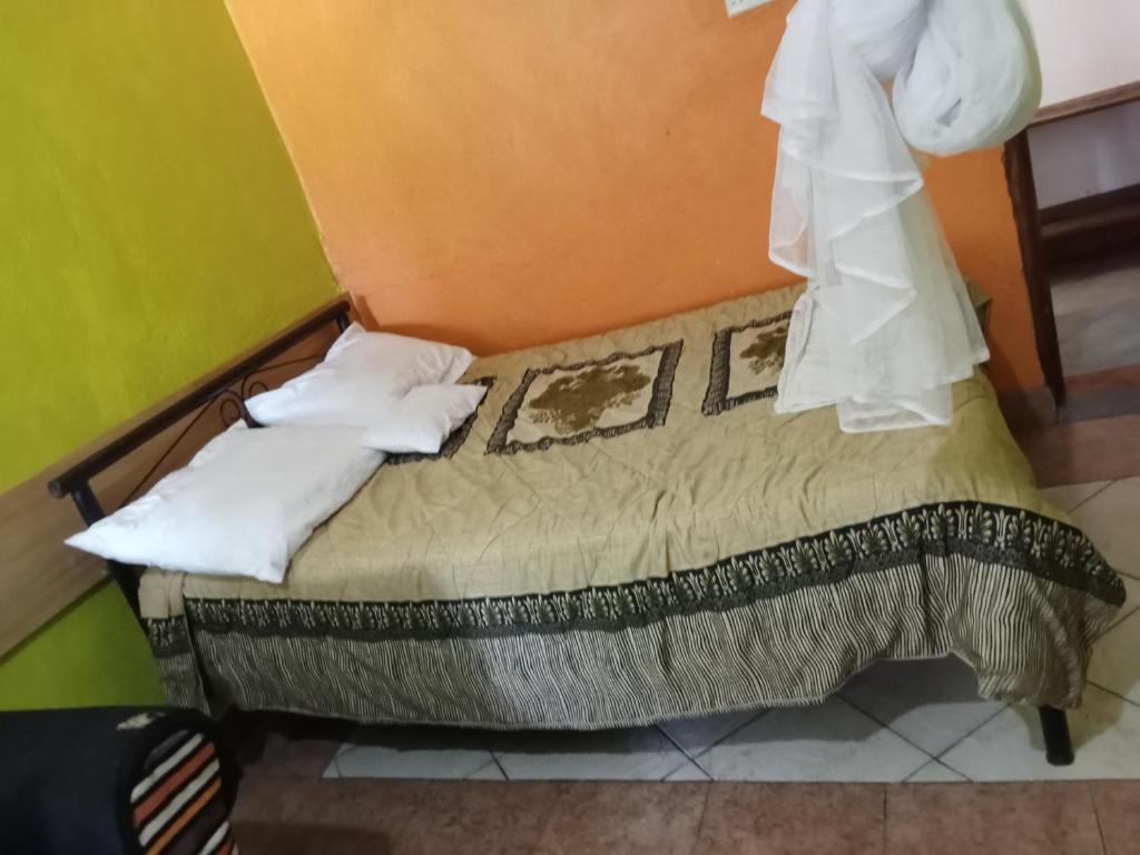 a bedroom with a bed with white pillows on it at Yaya kilimani cottage B in Nairobi