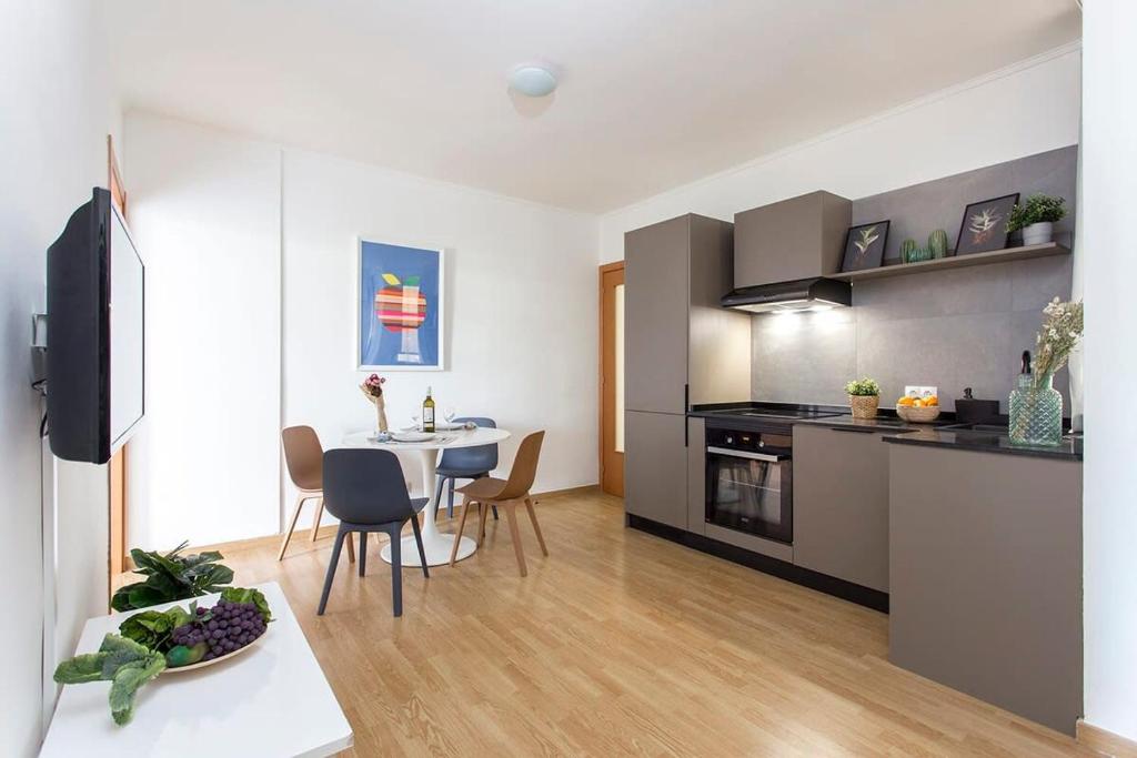 cocina y sala de estar con mesa y sillas en Sunny 3BD apartment in Poblenou next to the beach en Barcelona