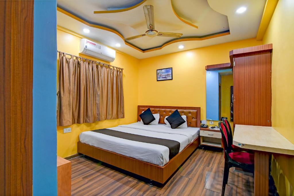 a hotel room with a bed and a desk and a table at BRILL A G STAR 500m from International Airport in kolkata