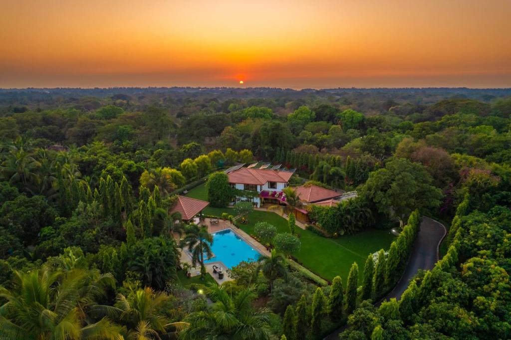an aerial view of a villa with a swimming pool and a sunset at StayVista at Moksh Villa in Alibaug