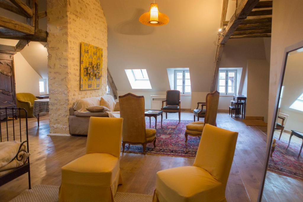 a living room with yellow chairs and a table at La Maison du Haut in Tonnerre