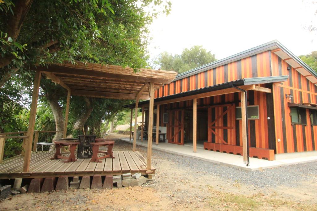 a large wooden building with a porch at うふた in Tatsugo