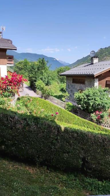 Elle offre une vue sur une maison et un jardin fleuri. dans l'établissement Belle maison traditionnelle - Les Chavonnes, à Courchevel
