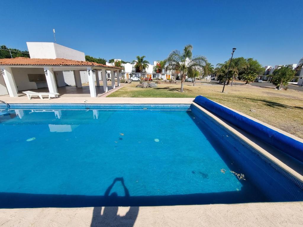 a blue swimming pool in front of a house at Casa con alberca Lomas de San Pedro SD in Querétaro
