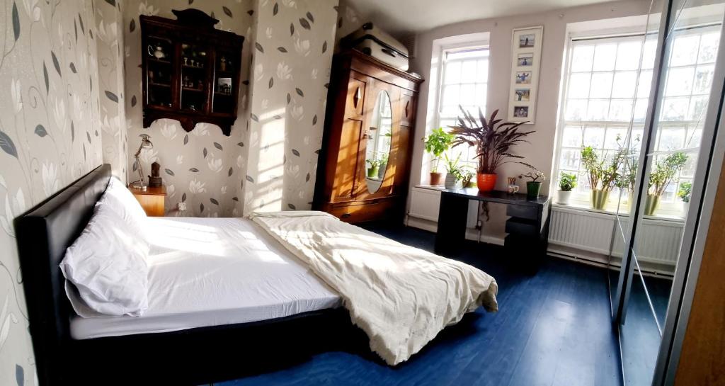 a bedroom with a bed in a room with windows at Double room near Highgate in London