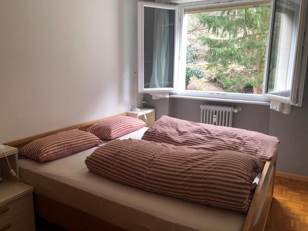 two beds in a bedroom with a window at Guesthouse Gigli 2 - Garage piccolo & Tourist Card in Bolzano
