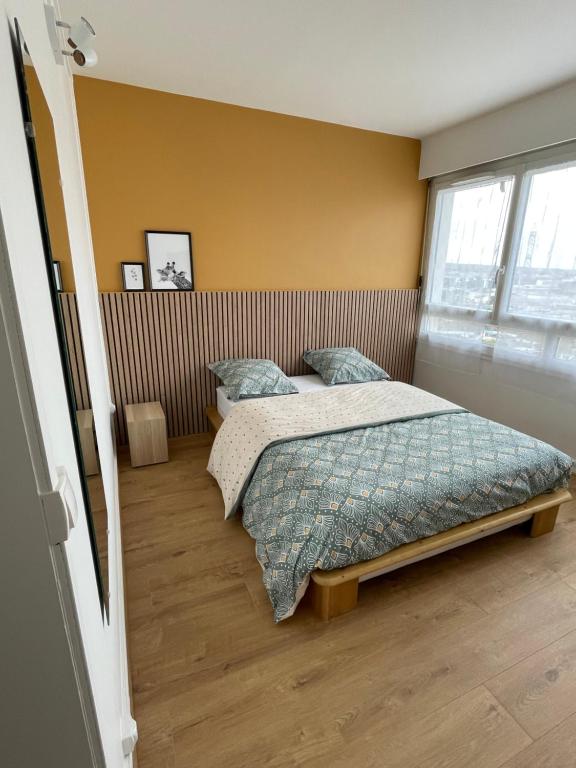um quarto com uma cama e uma janela em Coliving - chambre jaune em Sarcelles