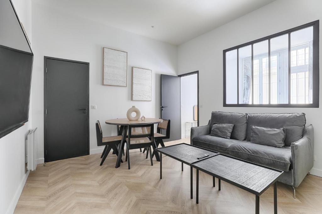 un salon avec un canapé et une table dans l'établissement Mogador - Opéra Haussmann Charming Apartment 4P 1BDR, à Paris