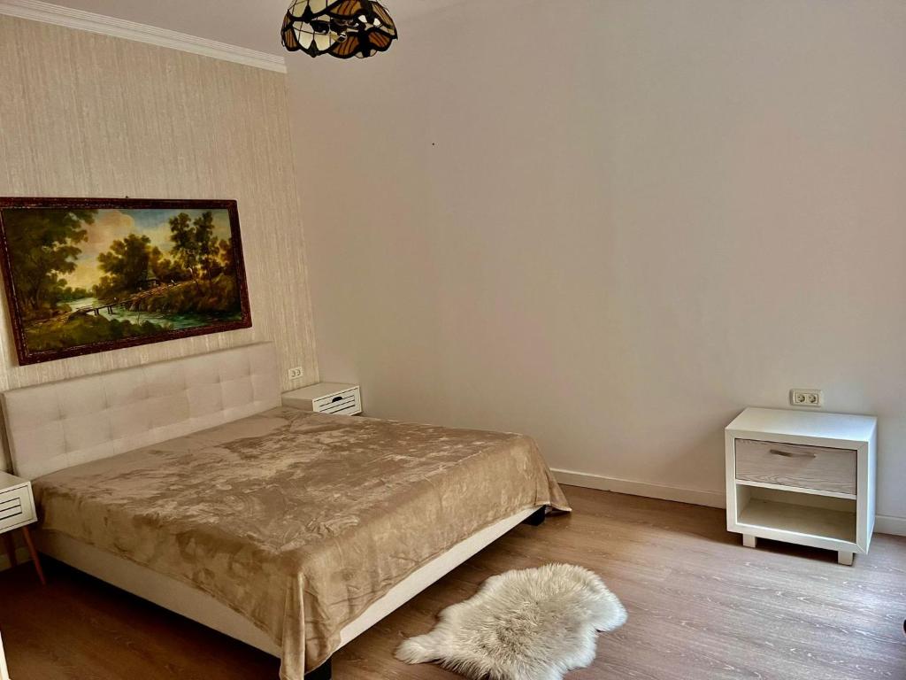 een slaapkamer met een bed en een schilderij aan de muur bij Cazino Suites in Constanţa