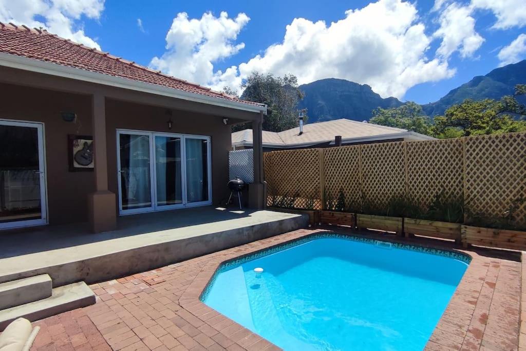 a swimming pool in front of a house at Scenic house with splash pool in Cape Town