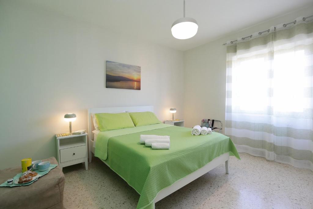 a bedroom with a bed with a green blanket at La Coccinella Sorrento in Sorrento