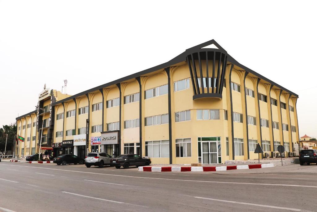 un gran edificio amarillo en el lateral de una calle en Hotel Hayatt Atlantique, en Nouakchott