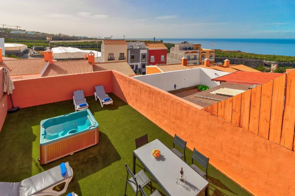 ein orangefarbenes Gebäude mit Pool auf dem Dach in der Unterkunft Nice House Nina With Jacuzzi in Playa de San Juan