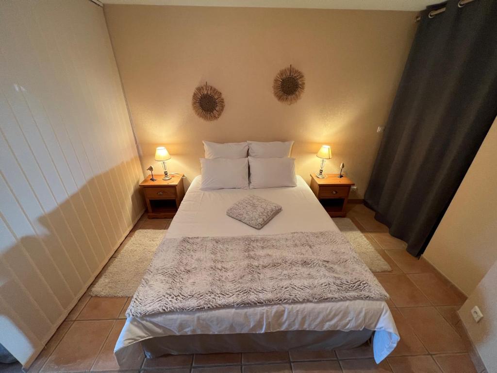 ein Schlafzimmer mit einem Bett mit zwei Lampen an zwei Tischen in der Unterkunft Appartement cocooning & love in Allex