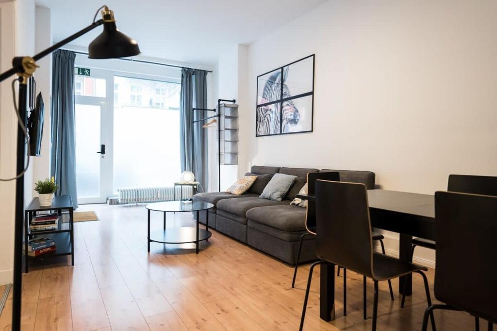 a living room with a couch and a table at Great Apartment for Eight in Berlin Neukölln in Berlin