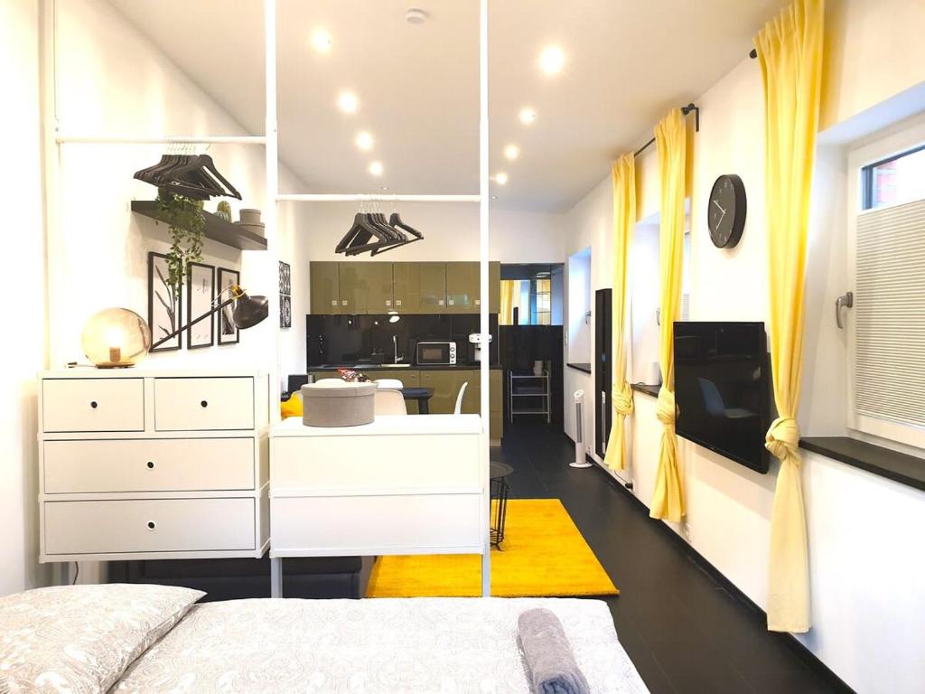 ハンブルクにあるCosy Studio with Private Parkingのベッドルーム(白い家具、大きな鏡付)