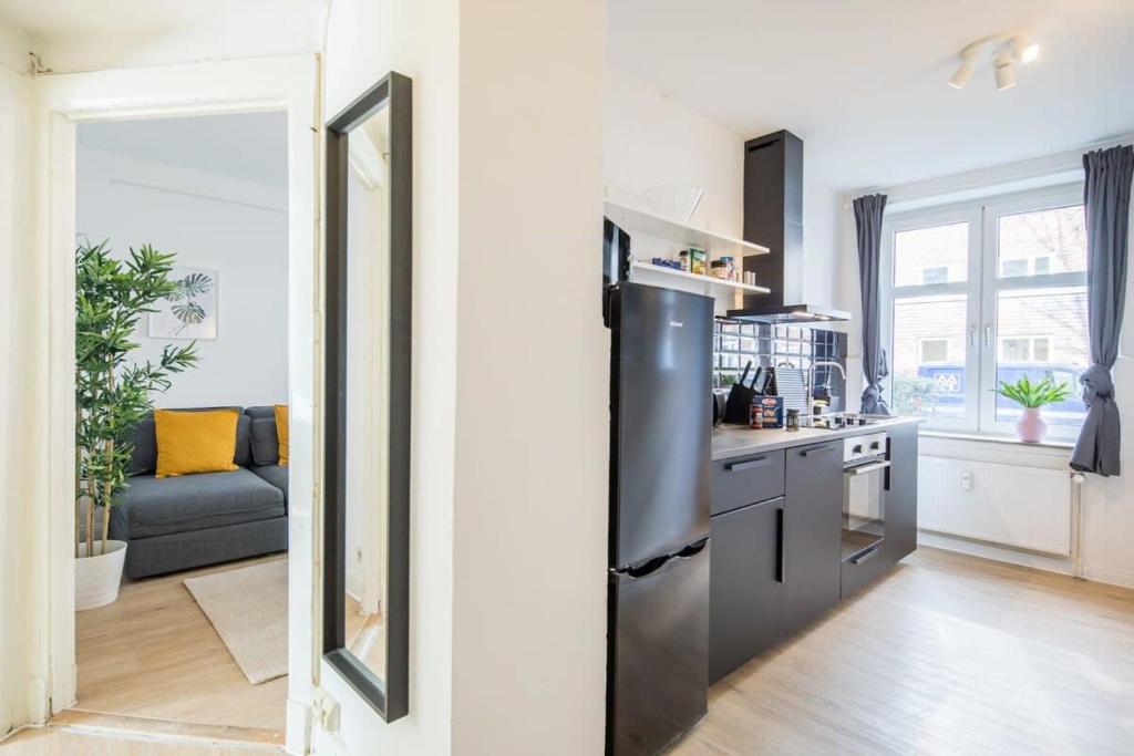 a kitchen with a stainless steel refrigerator and a stove at Schickes zwei Zimmer Apartment Kostenl Parkm auf der Strasse in Hamburg