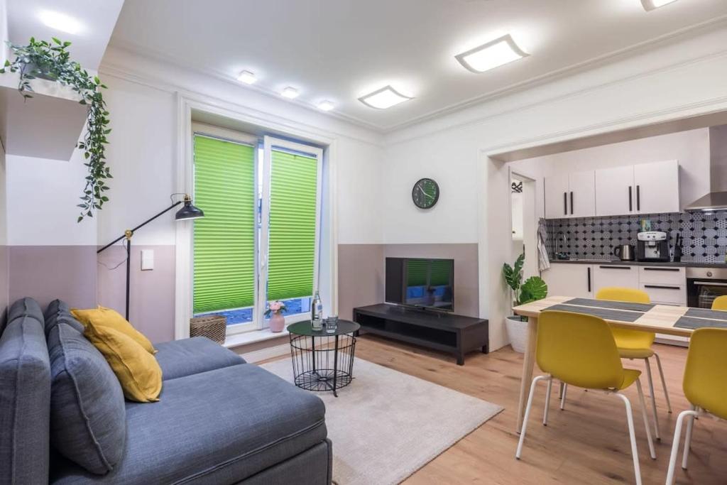een woonkamer met een blauwe bank en een keuken bij Charming Apartment in prime location in Hamburg