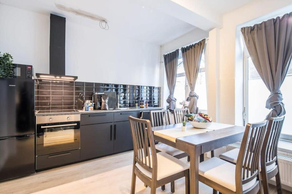 une cuisine avec une table et des chaises dans une cuisine dans l'établissement Cosy 2-room Apartment in urban location, à Hambourg