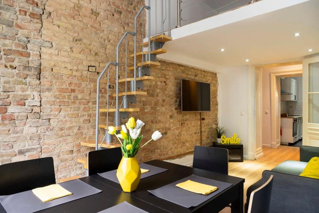 uma sala de jantar com uma mesa e uma parede de tijolos em Industrial Style plus Self Checkin plus Street Parking em Berlim
