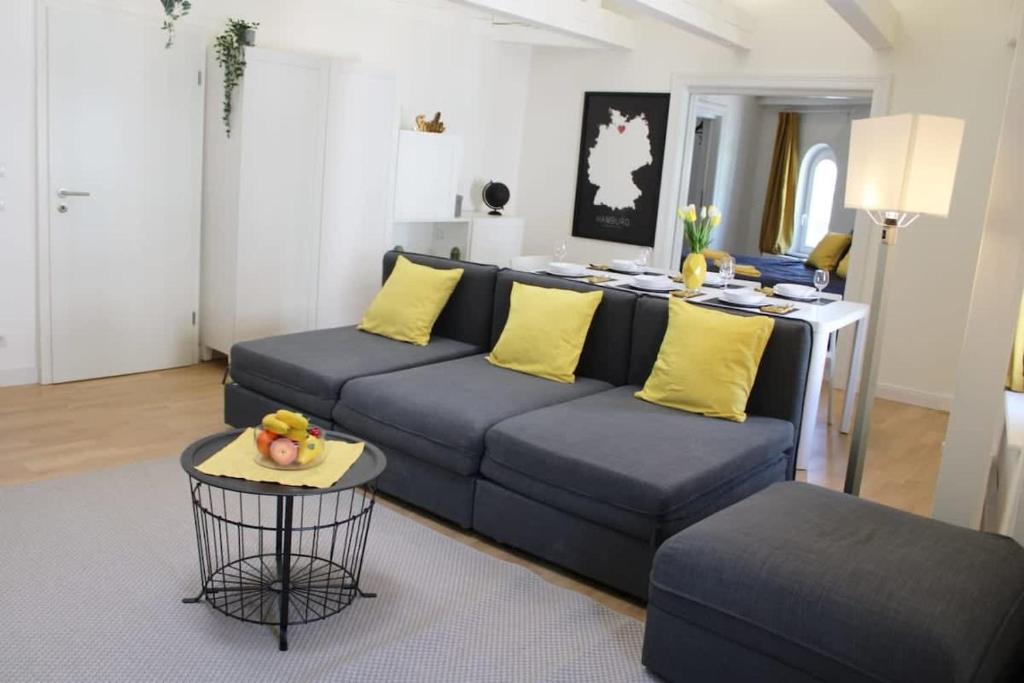 - un salon avec un canapé bleu et des oreillers jaunes dans l'établissement Hamburger Perle am Gänsemarkt und Binnenalster, à Hambourg