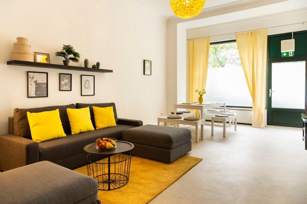 een woonkamer met een bruine bank en gele kussens bij Modern 2 Bedroom Apartment in Berlin Schöneberg in Berlijn
