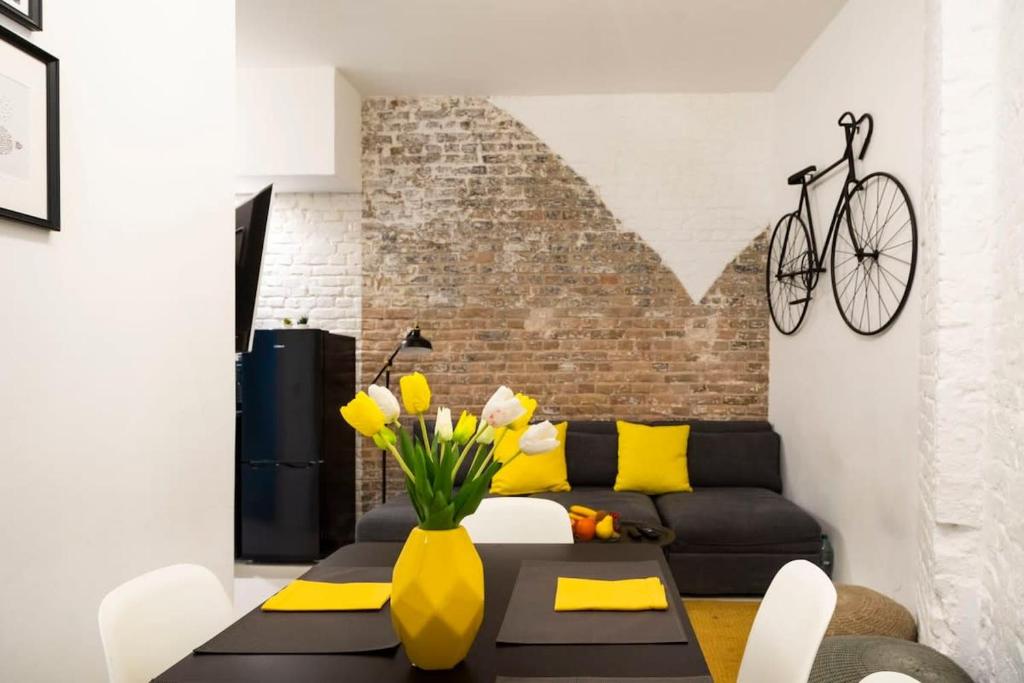 a living room with a couch and a bike on the wall at Cosy Three BR Two BTH plus AC plus Self CheckIn plus Street Parking in Berlin