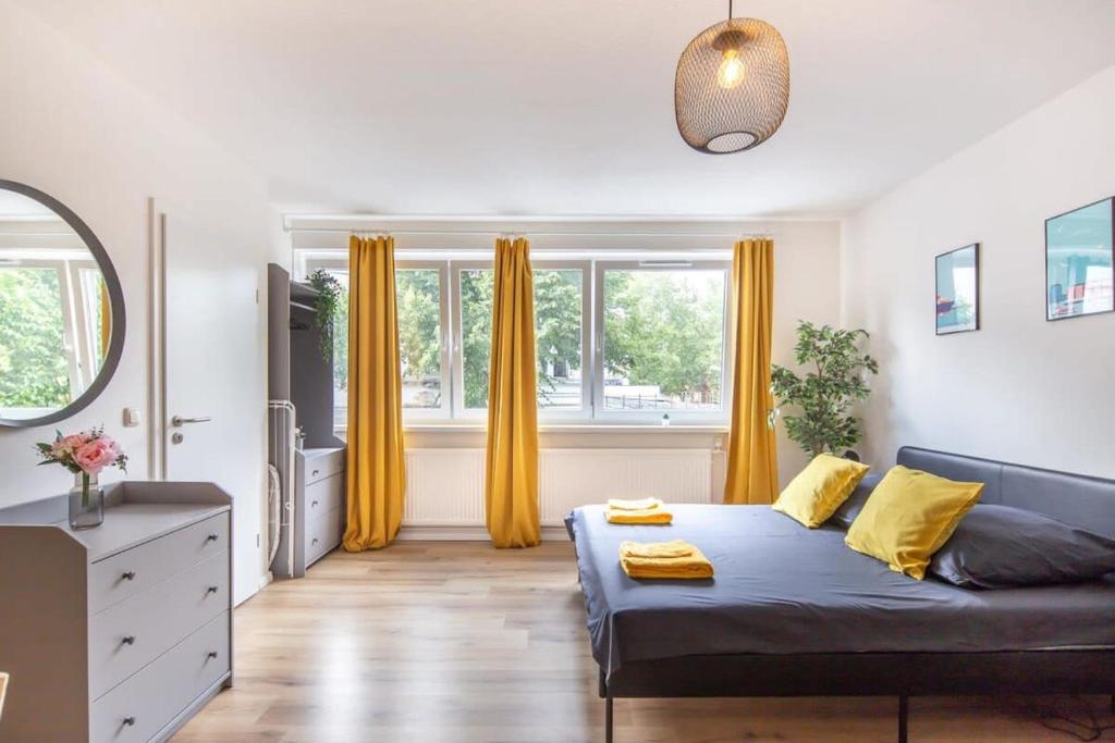 - un salon avec un lit et des rideaux jaunes dans l'établissement Schulterblatt-Apartments Hamburg Unit 3 For 5, à Hambourg