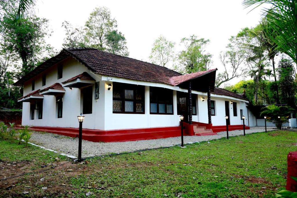 a small white house with a red trim at Coorg Mystere - Luxury Homestay in Madikeri