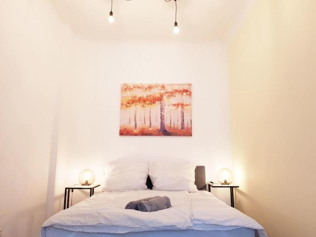 a bedroom with a bed with a painting on the wall at Family Apartment Moabit in Berlin