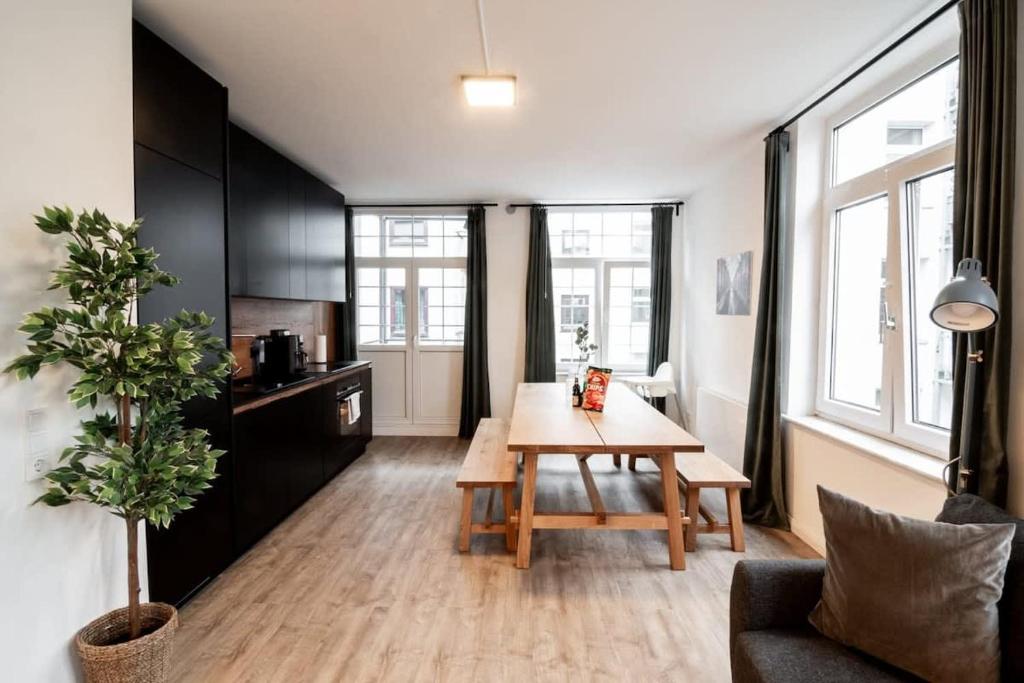 a living room with a wooden table and a kitchen at Hamburg Gem for 12 in Hamburg