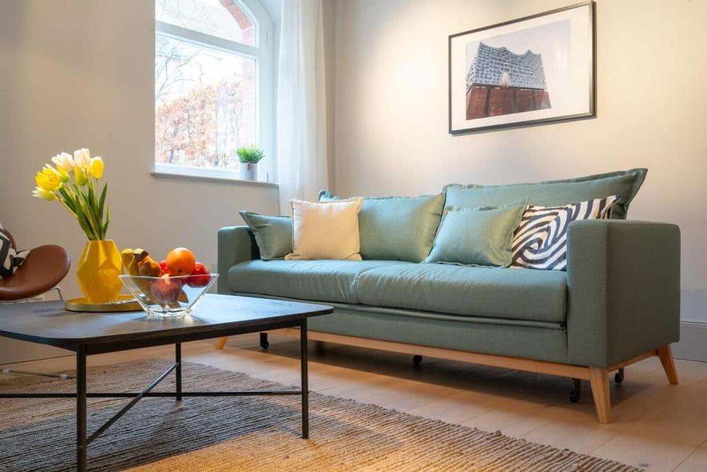 sala de estar con sofá azul y mesa en Spacious 3-bedroom apartment near Eilbekpark, en Hamburgo