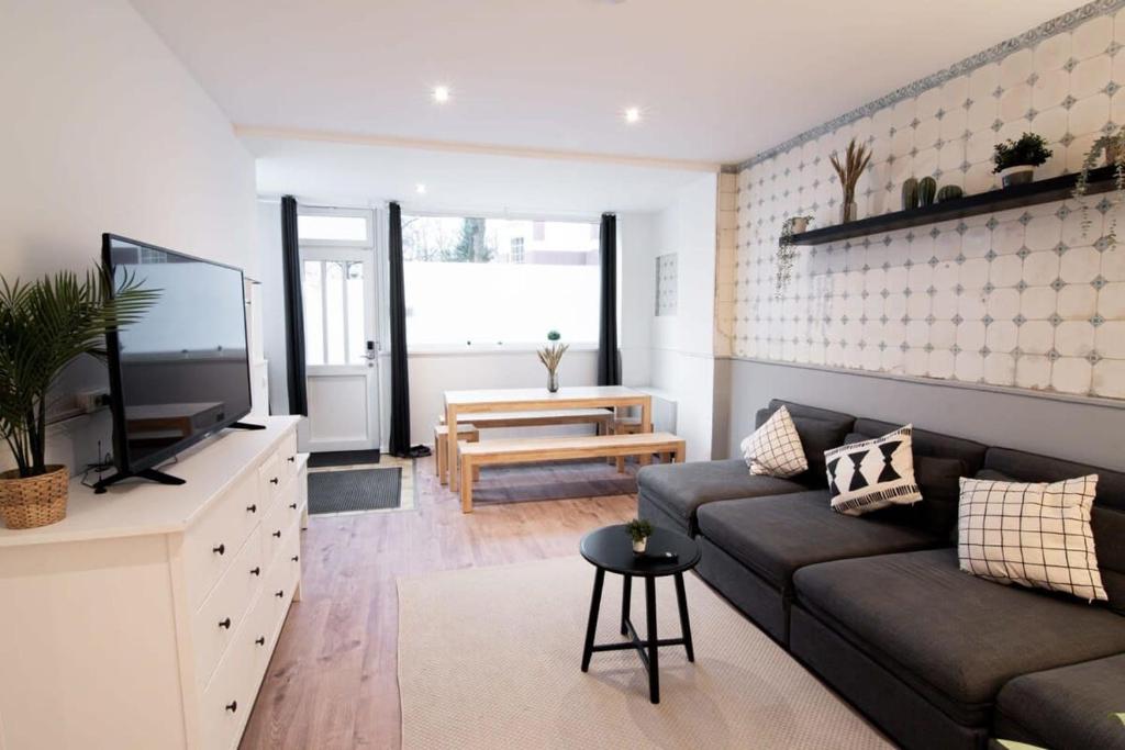 ein Wohnzimmer mit einem Sofa und einem TV in der Unterkunft Great Three Bedroom Apartment in Hamburg