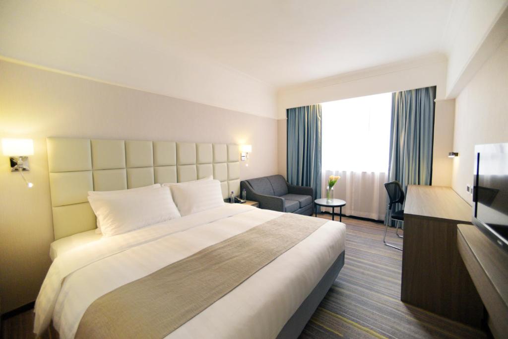 a hotel room with a large bed and a television at Panda Hotel in Hong Kong